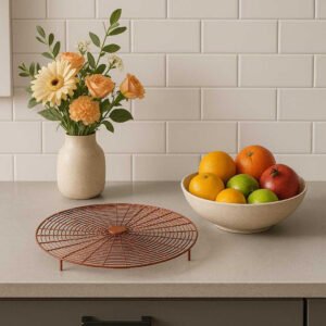 Beskyttelsesrist i Metal - Praktisk og Elegant Design i Brun og Sort til Hjemmet. The elegant protective grill is showcased on a modern kitchen counter, highlighting its sleek design beside a vase of fresh flowers and a bowl of colorful fruits.