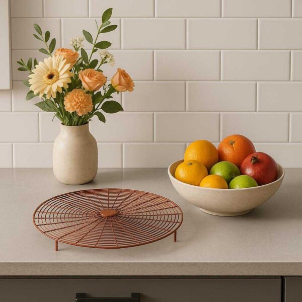 Beskyttelsesrist i Metal - Praktisk og Elegant Design i Brun og Sort til Hjemmet. The elegant protective grill is showcased on a modern kitchen counter, highlighting its sleek design beside a vase of fresh flowers and a bowl of colorful fruits.