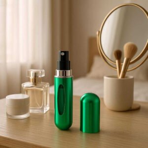 Genopfyldelig Parfumespray i Moderne Design - Tilgængelig i 7 Farver. A chic vanity table in a cozy, softly-lit bedroom, where the Genopfyldelig Parfumespray in a sleek emerald color is elegantly placed among other personal care items. The spray is open, suggesting it has just been used. Diffuse morning light filters through sheer curtains, casting gentle shadows and enhancing the modern design with a touch of luxury and daily comfort.