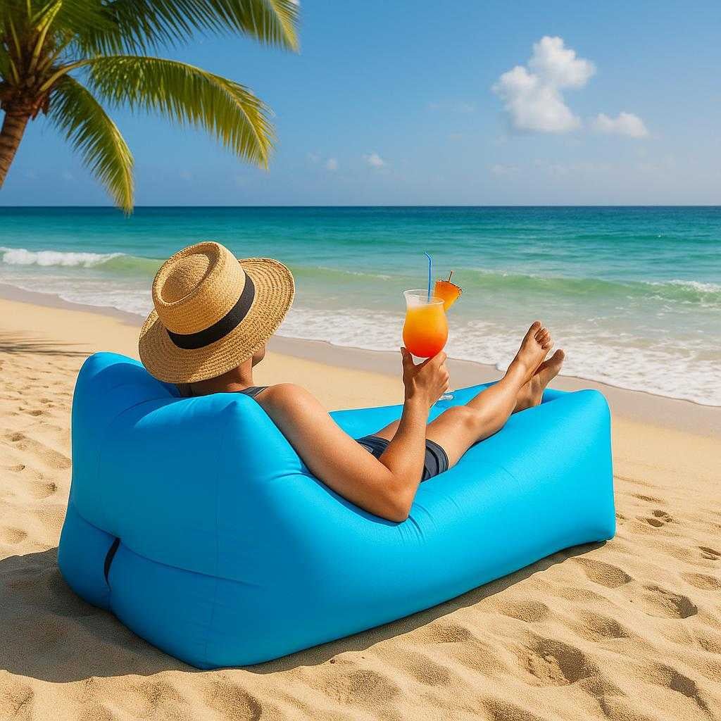 luftsofa-oppustelig-sofa-til-strand-camping-outdoor-i-bl-grn-orange-sort-the-blue-inflatable-sofa-is_15245555270019_scene1 Luftsofa – Oppustelig Sofa til Strand, Camping, Outdoor i Blå, Grøn, Orange, Sort. The blue inflatable sofa is positioned on a sunny beach, surrounded by white sand and ocean waves, with a person relaxing comfortably, enjoying a tropical drink.