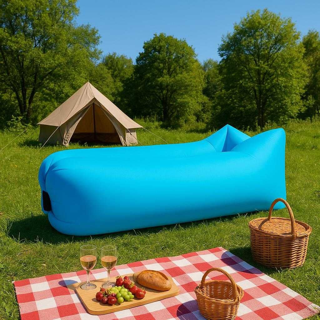luftsofa-oppustelig-sofa-til-strand-camping-outdoor-i-bl-grn-orange-sort-the-blue-inflatable-sofa-is_15245555270019_scene2 Luftsofa – Oppustelig Sofa til Strand, Camping, Outdoor i Blå, Grøn, Orange, Sort. The blue inflatable sofa is set up in a lush green campsite, with a cozy picnic setup and a tent in the background under the clear blue sky.