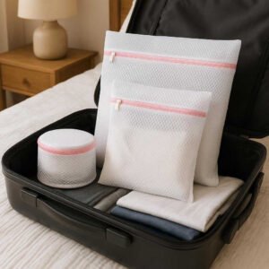Polyester Net Poser - 4 Stk, Polyester, Plastik, Netkonstruktion, Beskytter Tøj: A different realistic travel setting where the product is securely positioned in an open suitcase on a bed, being used to neatly organize clothes for a trip, with proper physics, shadows, and realistic integration into the cozy bedroom environment.